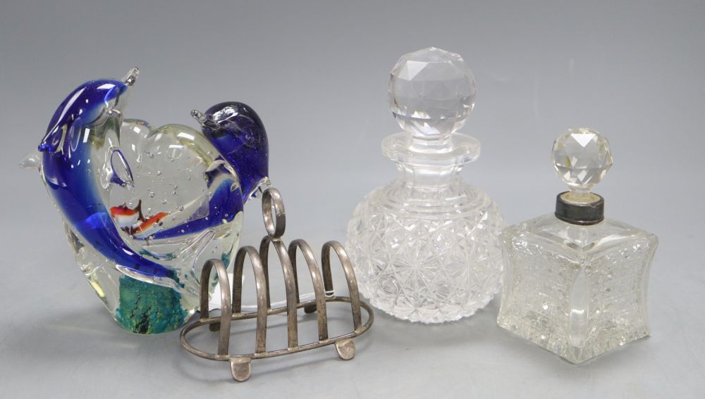An Italian glass model of dolphins inset with fish, two scent bottles and a silver toast rack